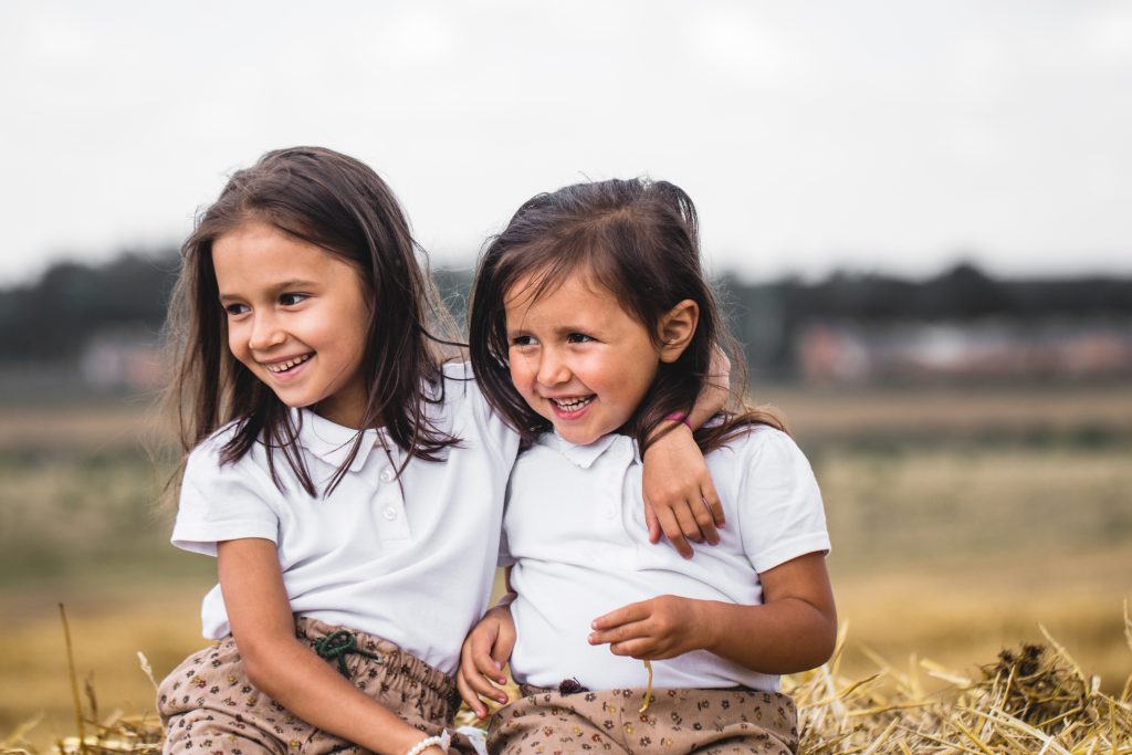 Dos niñas sonriendo en el campo